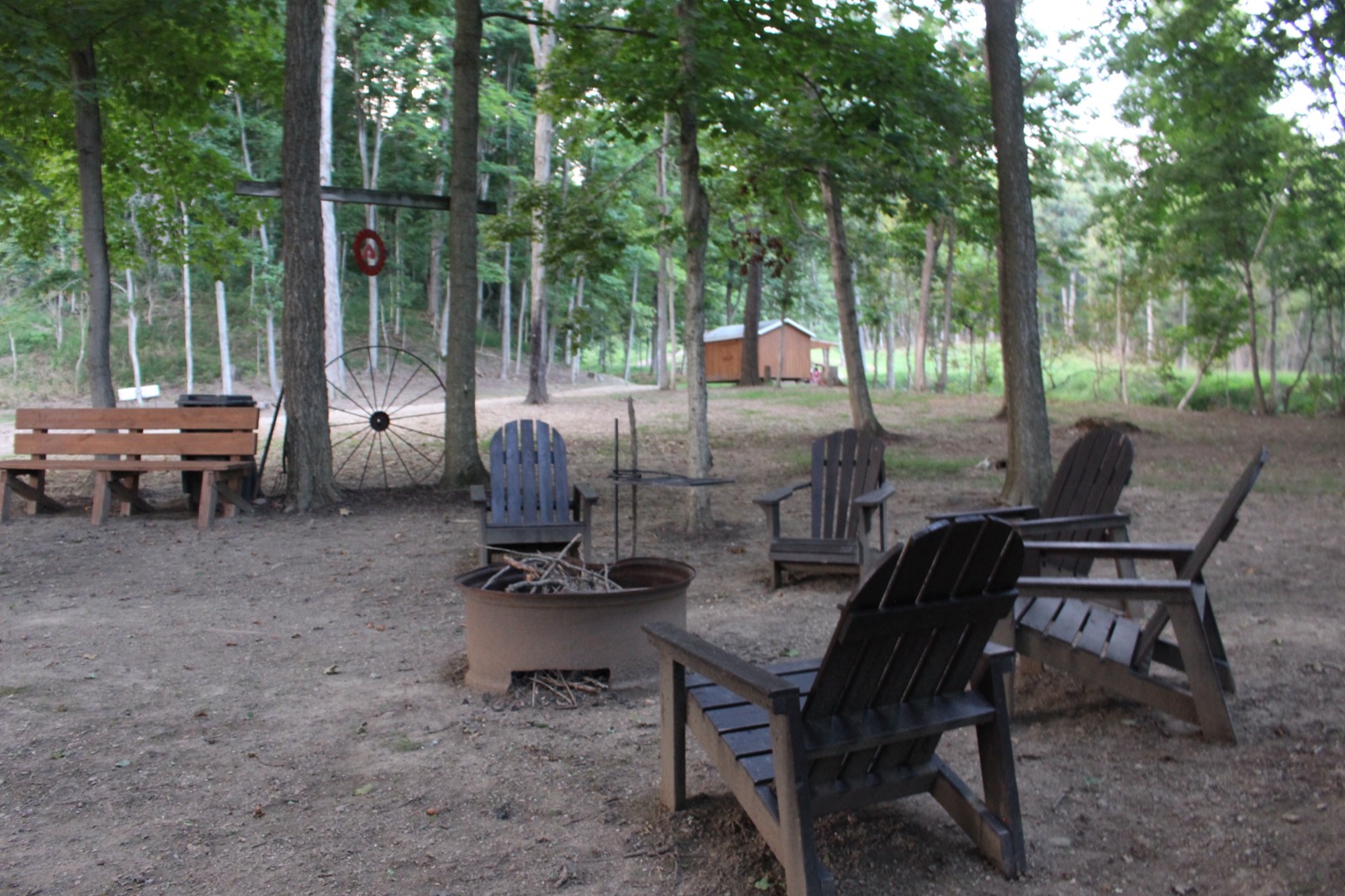 Firepit gathering area with a wagon wheel and shed